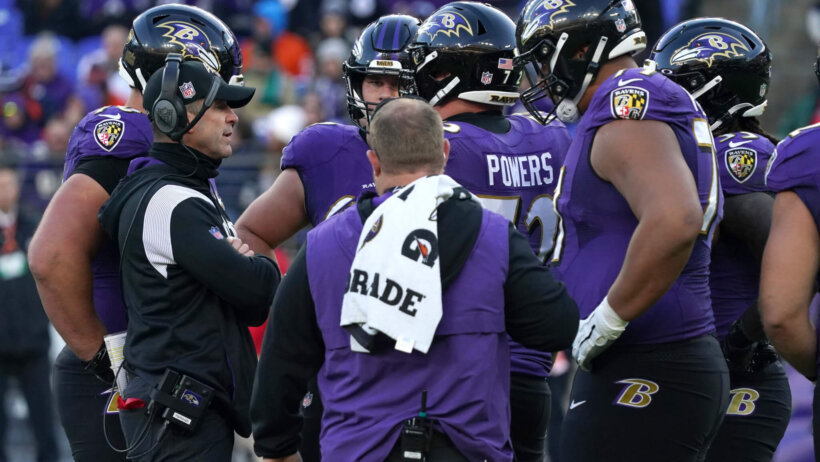 John Harbaugh huddles up with his team.
