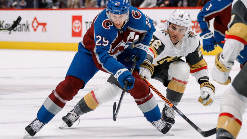 Colorado Avalanche center Nathan MacKinnon controls the puck under pressure from Vegas Golden Knights