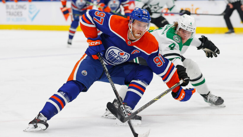 Edmonton Oilers forward Connor McDavid carries the puck around Dallas Stars defensemen Miro Heiskanen