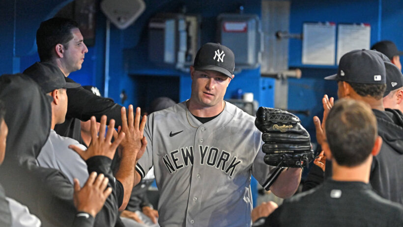 Gerrit Cole high-fives teammates in the dugout