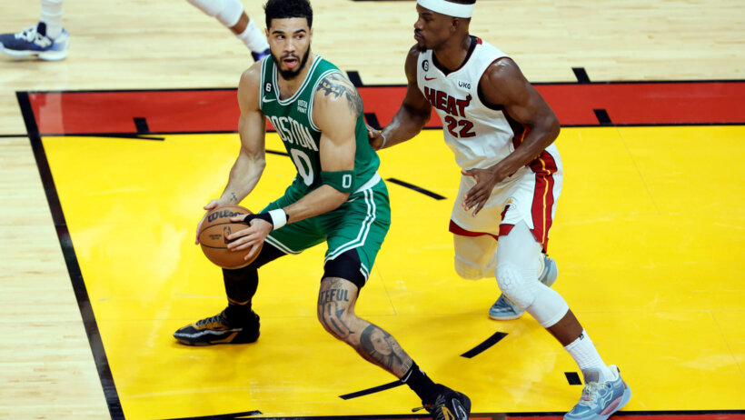 Boston Celtics forward Jayson Tatum backing down Miami Heat forward Jimmy Butler