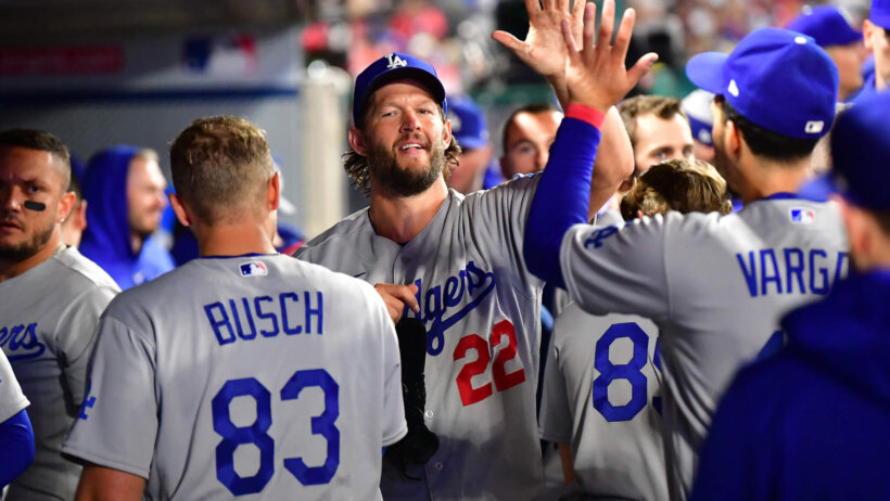 Clayton Kershaw high-fives teammates in the dugout