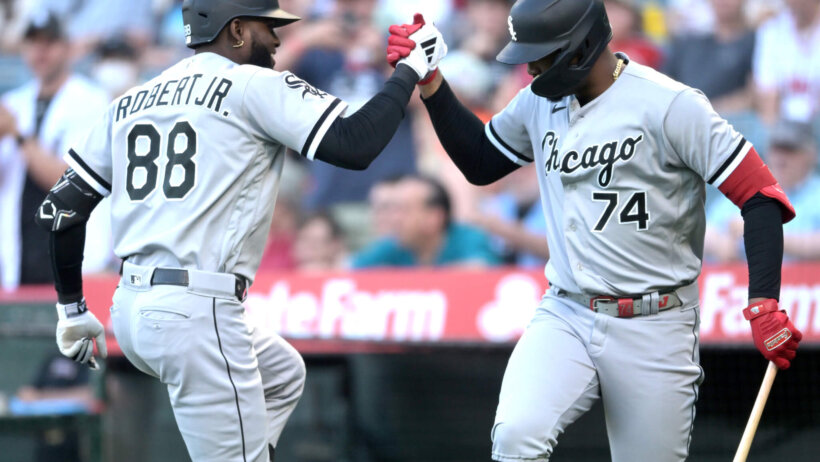 Chicago White Sox center fielder Luis Robert Jr celebrates with designated hitter Eloy Jimenez