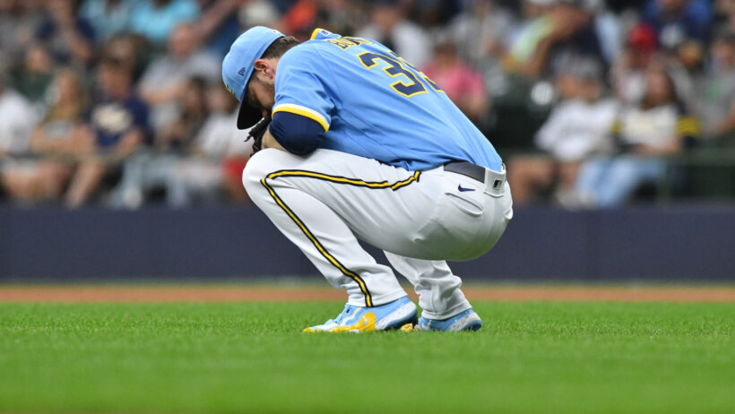 Milwaukee Brewers starting pitcher Corbin Burnes crouching on the mound