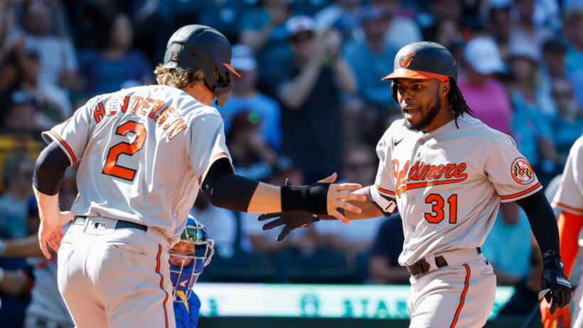 Cedric Mullins celebrates at home plate with Gunnar Henderson