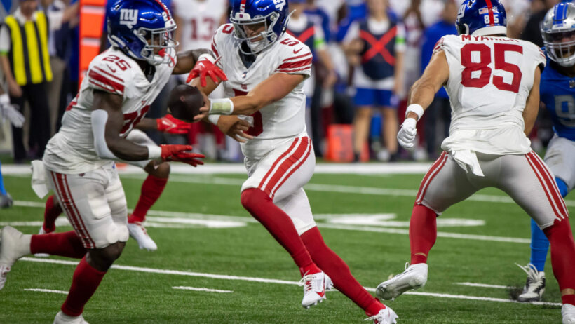 New York Giants QB Tommy DeVito hands off ball.