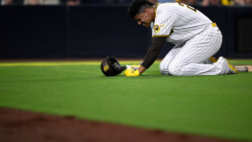 San Diego Padres left fielder Juan Soto kneels on the grass
