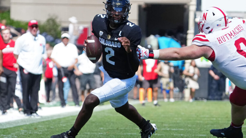 Colorado Buffaloes quarterback Shedeur Sanders scrambles past Nebraska Cornhuskers defensive lineman Nash Hutmacher