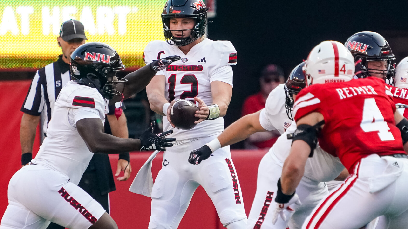 Northern Illinois Huskies quarterback Rocky Lombardi hands the ball off to running back Antario Brown