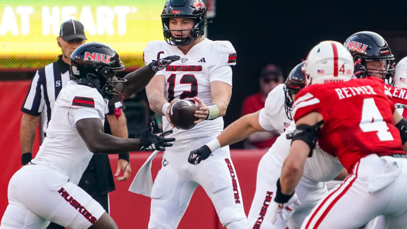 Northern Illinois Huskies quarterback Rocky Lombardi hands the ball off to running back Antario Brown