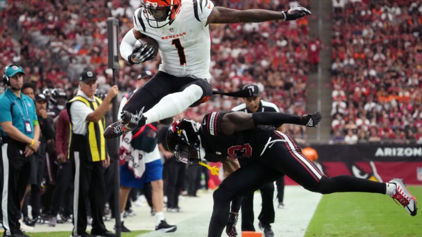 Cincinnati Bengals receiver Ja'Marr Chase (1) leaps over Arizona Cardinals cornerback Kei'Trel Clark
