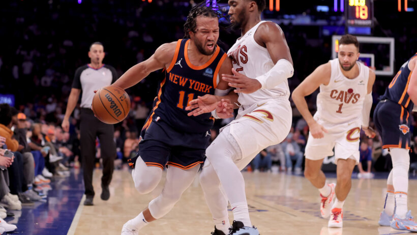 New York Knicks guard Jalen Brunson tries to dribble around Cleveland Cavaliers guard Donovan Mitchell