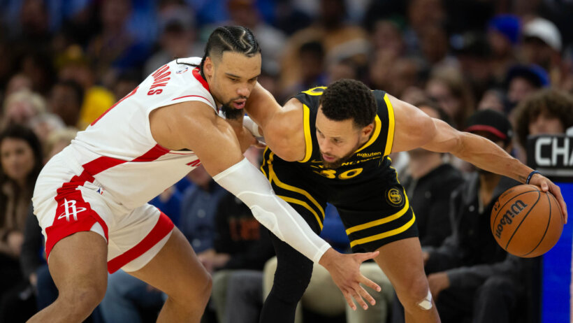 Golden State Warriors guard Stephen Curry holds off Houston Rockets guard Dillon Brooks