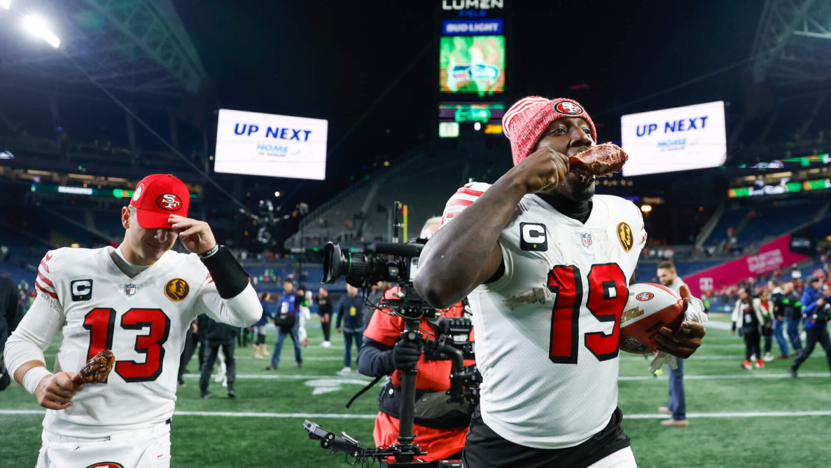 San Francisco 49ers wide receiver Deebo Samuel (19) eats a turkey leg as he and quarterback Brock Purdy (13) jog to the locker room