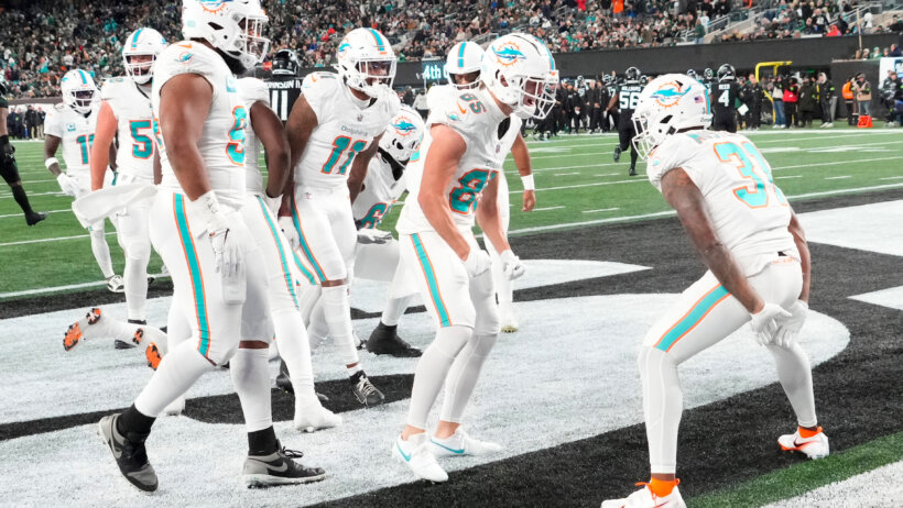 Miami Dolphins running back Raheem Mostert (31) joins his teammates in celebrating his second half touchdown