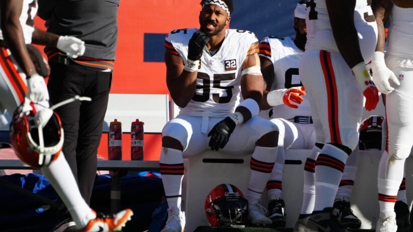 Cleveland Browns Myles Garrett sitting on bench scratching chin