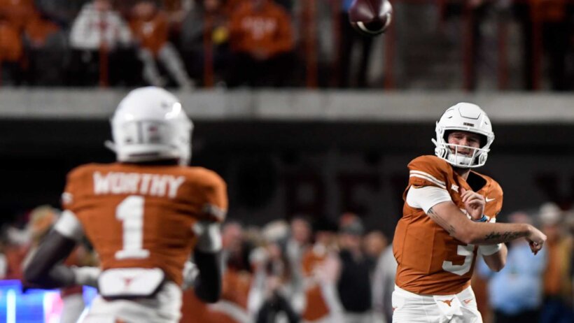 Texas' quarterback Quinn Ewers throws the ball to Texas' wide receiver Xavier Worthy