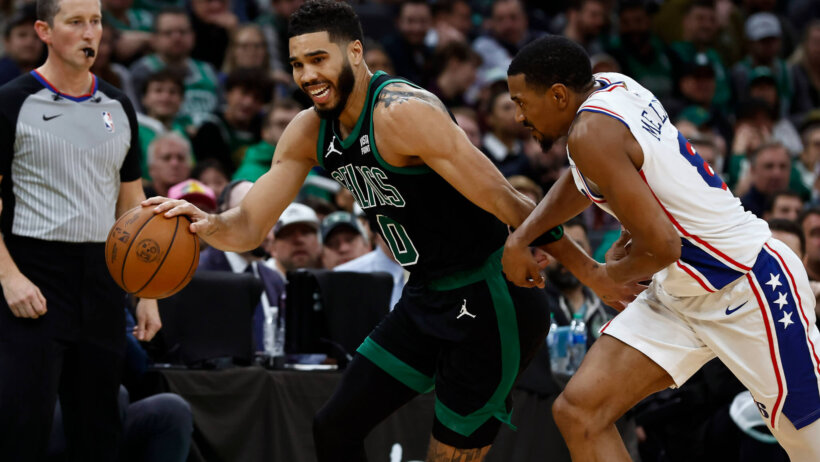 Boston Celtics forward Jayson Tatum tries to hold off Philadelphia 76ers guard De'Anthony Melton
