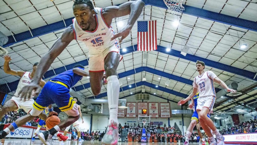 Delaware State University Hornets forward Wesley Oba (15) braces for a fall as University of Delaware Blue Hens guard Jalun Trent (2) moves the ball during the annual men's basketball game at DSU's Memorial Hall in Dover, Wednesday, Nov. 15, 2023. The Hens won 78-67.