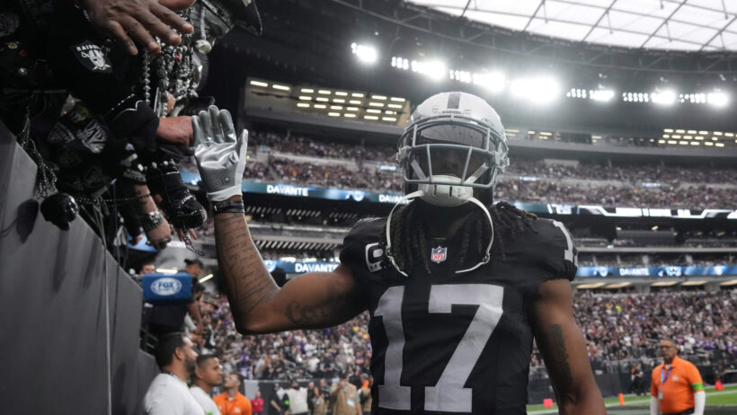 Las Vegas Raiders receiver Davante Adams high-fiving fans black jersey