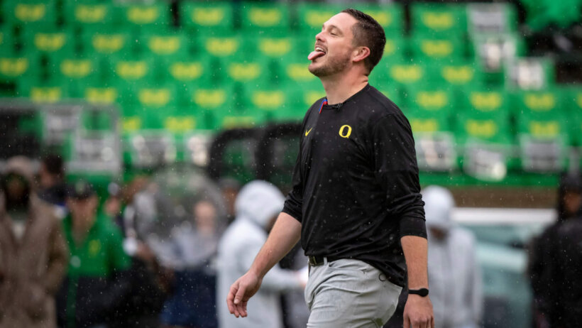 Dan Lanning sticks his tongue out to catch the rain