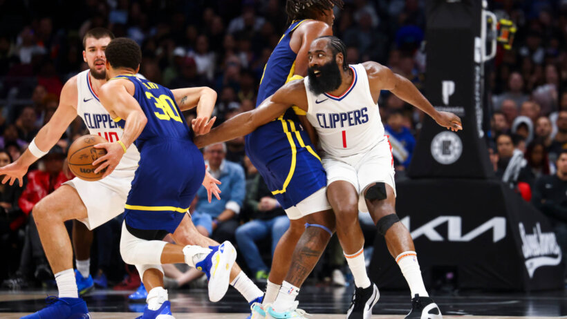 Golden State Warriors guard Stephen Curry drives around LA Clippers guard James Harden