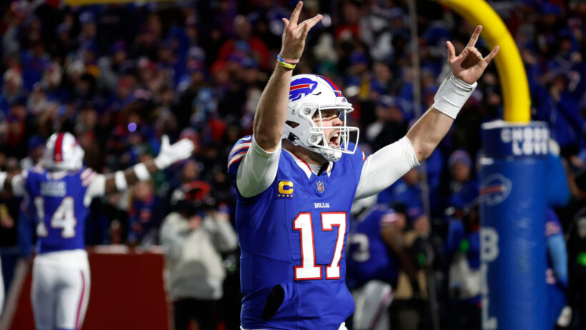 Buffalo Bills QB Josh Allen celebrating touchdown hands raised blue jersey