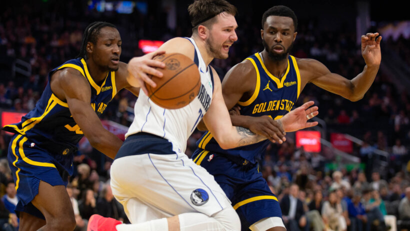 Dallas Mavericks forward Luka Doncic tries to dribble past Golden State Warriors forwards Jonathan Kuminga and Andrew Wiggins
