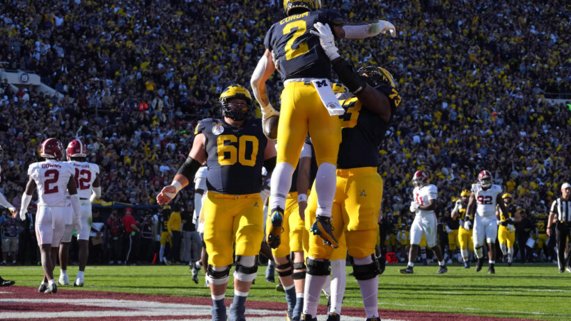 Michigan Wolverines running back Blake Corum is congratulated by offensive lineman LaDarius Henderson