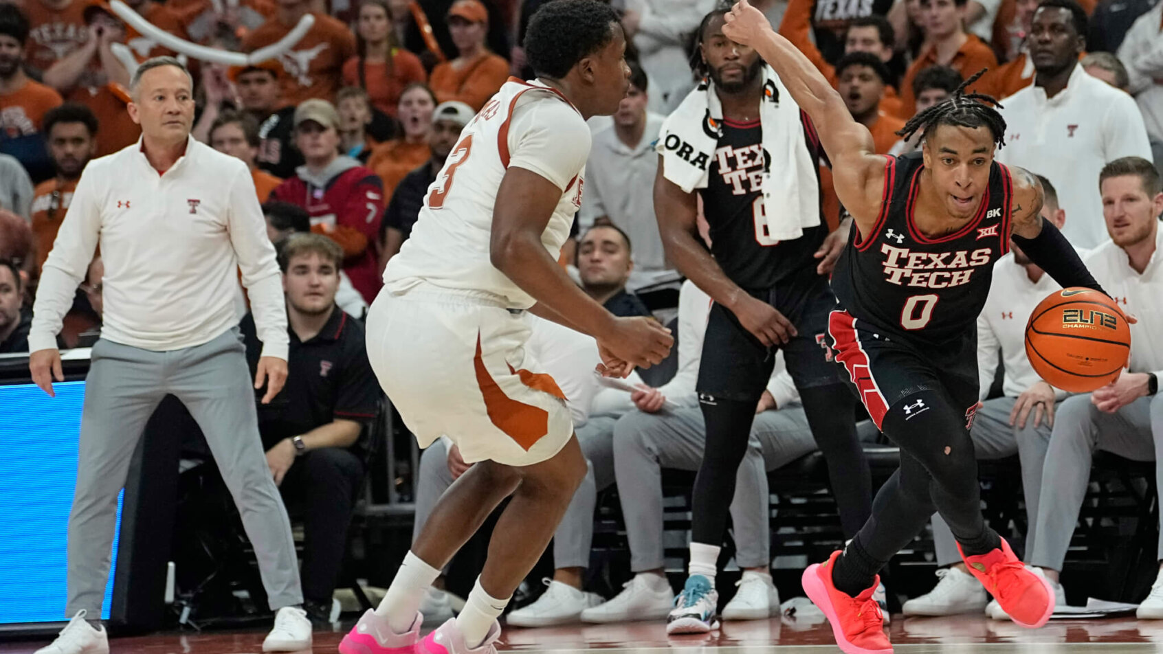 Texas Tech Red Raiders guard Chance McMillian dribbles past Texas Longhorns guard Max Abmas