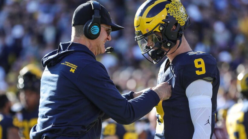 Michigan coach Jim Harbaugh talks to quarterback J.J. McCarthy