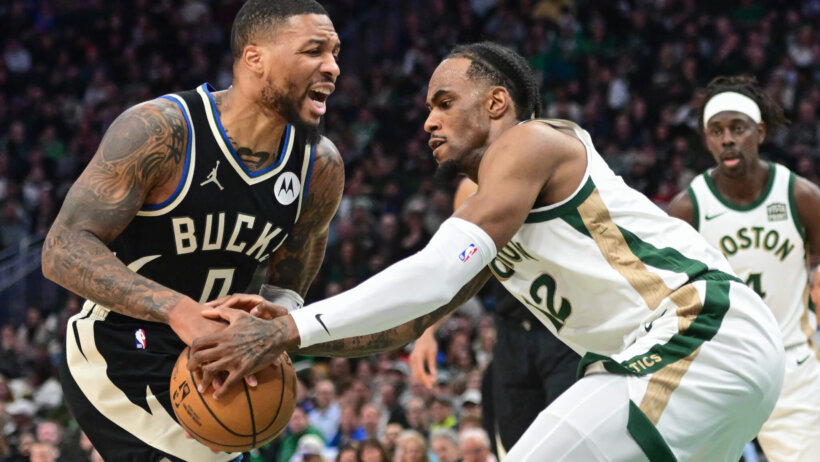 Milwaukee Bucks guard Damian Lillard and Boston Celtics forward Oshae Brissett battle for the ball
