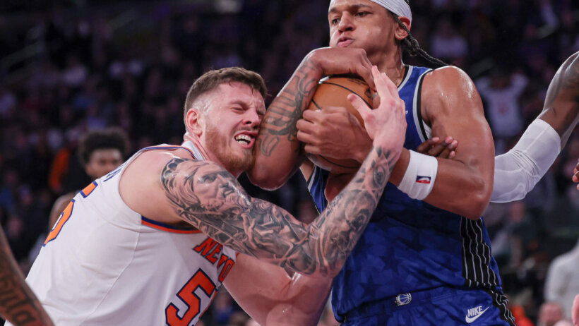 Orlando Magic forward Paolo Banchero wrestles for the ball with New York Knicks center Isaiah Hartenstein