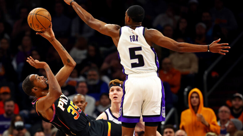Phoenix Suns forward Kevin Durant shoots while guarded by Sacramento Kings guard De'Aaron Fox