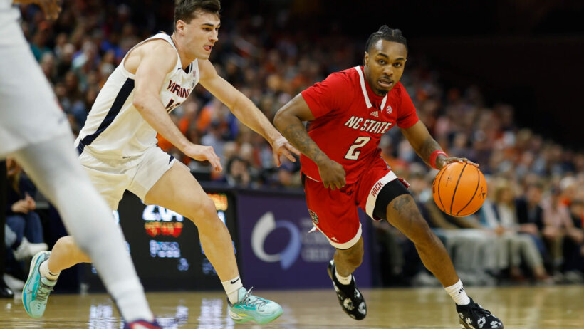 North Carolina State Wolfpack guard Kam Woods drives around Virginia Cavaliers guard Taine Murray