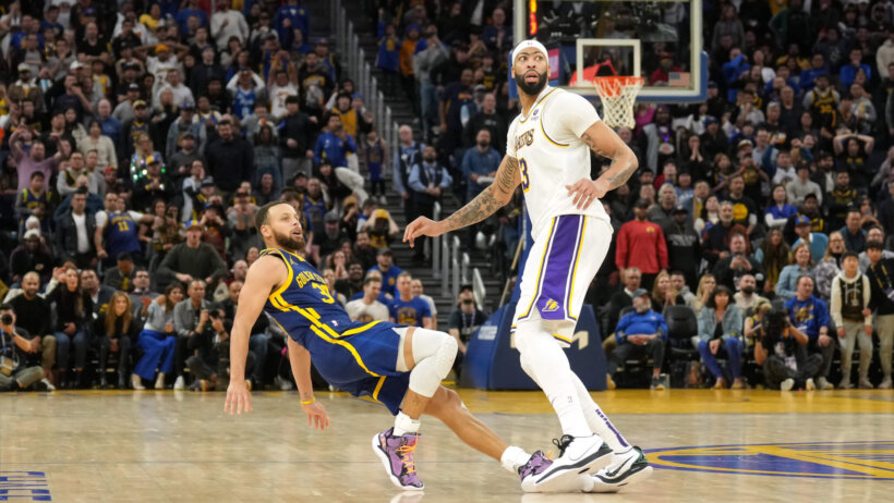Golden State Warriors guard Stephen Curry falls after shooting over Los Angeles Lakers forward Anthony Davis