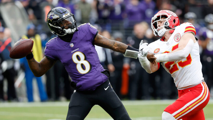 Lamar Jackson throws with pressure in his face.