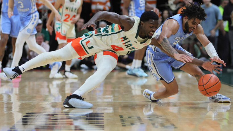 Miami Hurricanes guard Bensley Joseph and North Carolina Tar Heels guard RJ Davis go after a loose ball
