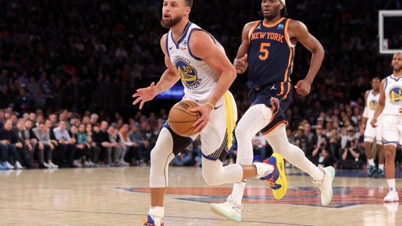 Golden State Warriors guard Stephen Curry drives to the basket as New York Knicks forward Precious Achiuwa looks on
