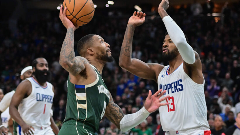 Milwaukee Bucks guard Damian Lillard drives against LA Clippers forward Paul George
