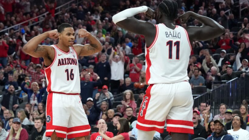 Arizona Wildcats basketball players Oumar Ballo and Keshad Johnson flexing their biceps.