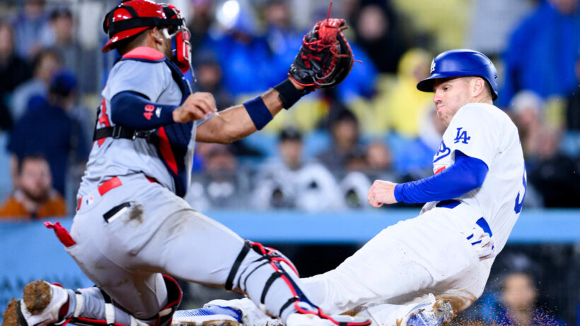 Los Angeles Dodgers first baseman Freddie Freeman slides into home as St. Louis Cardinals catcher Ivan Herrera tries to apply the tag