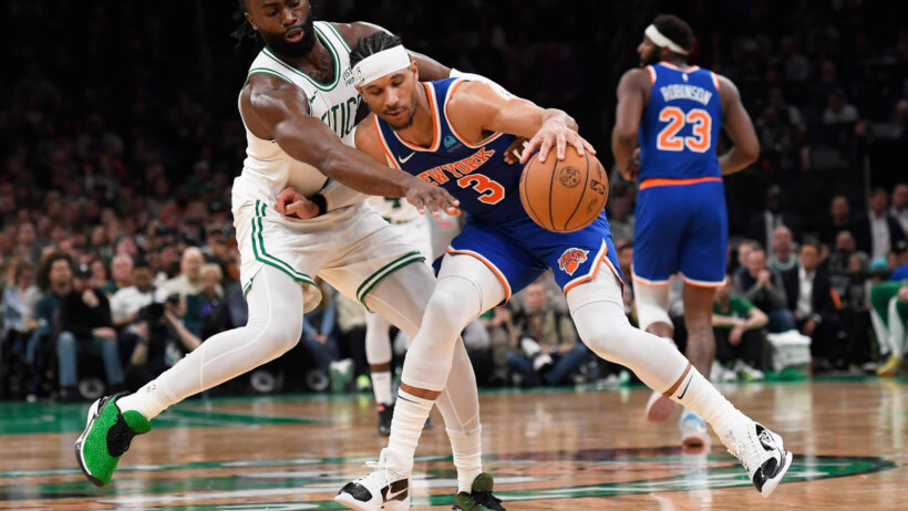 New York Knicks guard Josh Hart defends a basketball from Boston Celtics guard Jaylen Brown.