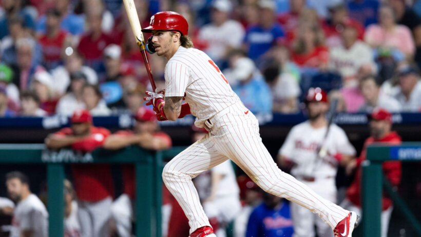 Philadelphia Phillies batter Bryson Stott begins to run after hitting a baseball.