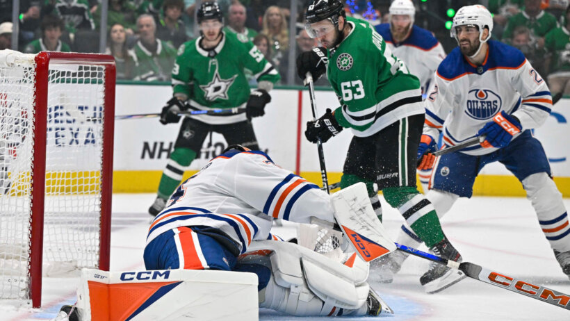 Edmonton Oilers goaltender Stuart Skinner making a save off of Dallas Stars right wing Evgenii Dadonov