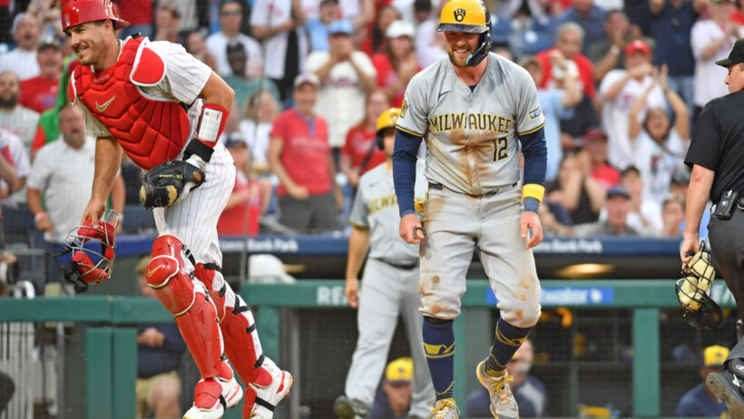 Milwaukee Brewers first baseman Rhys Hoskins laughs after Philadelphia Phillies catcher J.T. Realmuto tagged him out