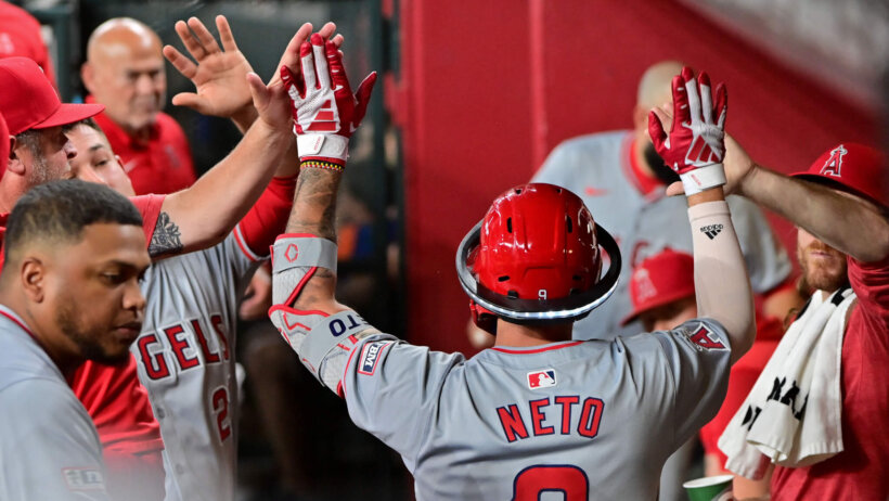 Zach Neto celebrating a home run in the dugout