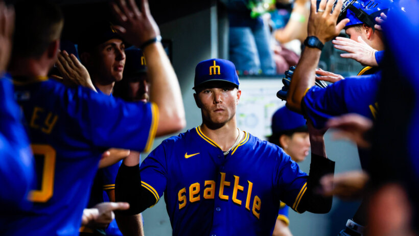 Seattle Mariners starting pitcher Bryan Woo high-fiving teammates in the dugout
