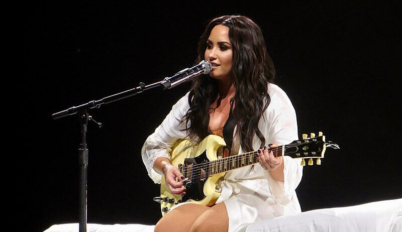 Demi Lovato singing at a concert.