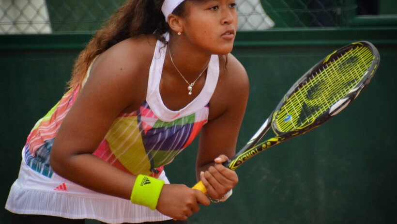 Naomi Osaka returning a serve.